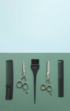 Kuaför aletleri, makas, tarak ve yeşil ve mavi arka planda fotokopi alanı ile fırça. Kuaför salonu için dikey şablon