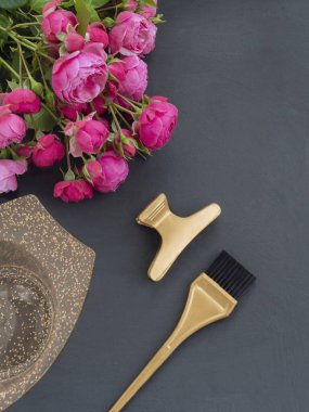 Koyu bir arka planda renk saçı ve güller için bir kase ve fırça ile şablon.