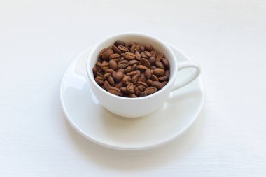 Masadaki beyaz bardakta kahve çekirdekleri..