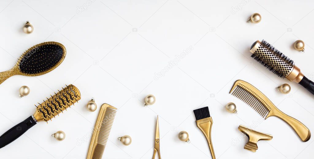 Banner with hairdressing tools in gold color and Christmas balls on a white background. A holiday template with accessories for a hair salon with space for text. Flat lay with Hairstylists scissors.