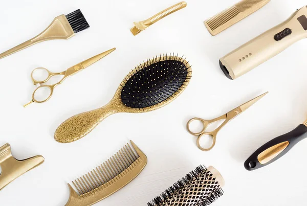 Background with golden hairdresser tools. Hair salon accessories, comb, scissors on white.