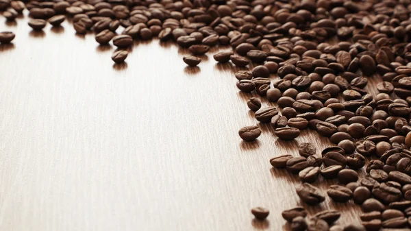 Kávová zrna na papíře pozadí — Stock fotografie