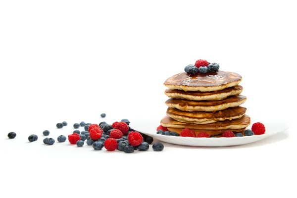 Pannkakor med honung och bär på vit bakgrund — Stockfoto