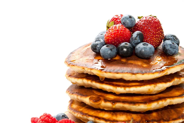 Pannkakor med honung och bär på vit bakgrund — Stockfoto