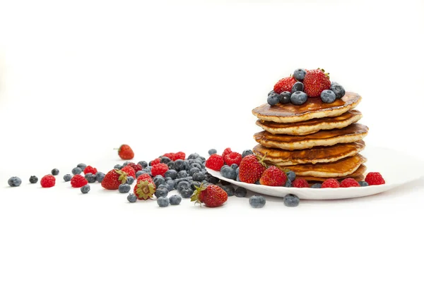Pfannkuchen mit Honig und Beeren auf weißem Hintergrund — Stockfoto