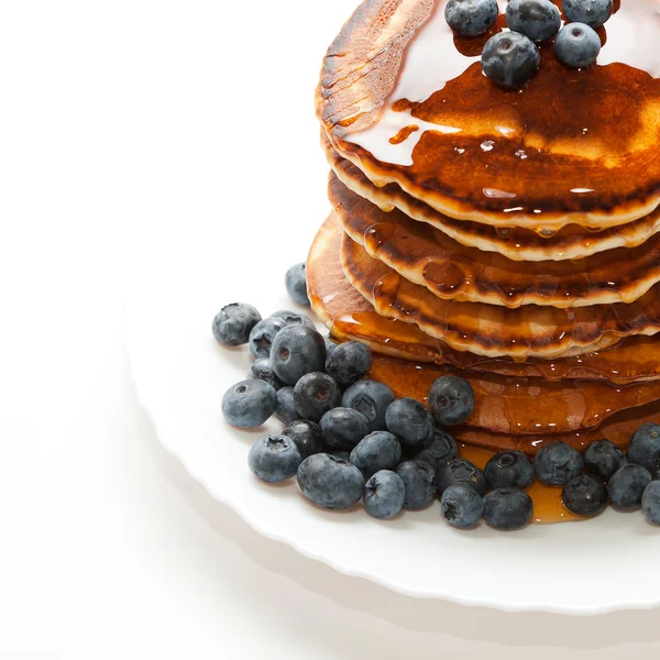 Pannkakor med honung och bär på vit bakgrund — Stockfoto