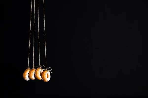 Свежие пончики на черном фоне — стоковое фото