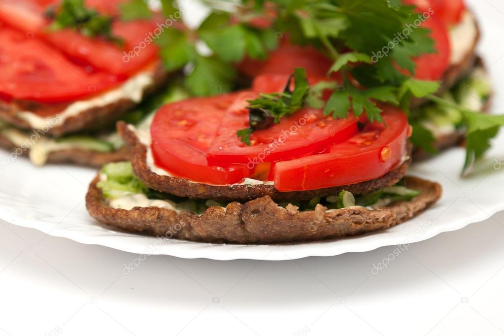 Liver meat cutlets with tomatoes and cucumbers over a white background