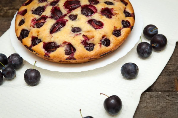 Torta di prugne su uno sfondo di legno scuro — Foto Stock