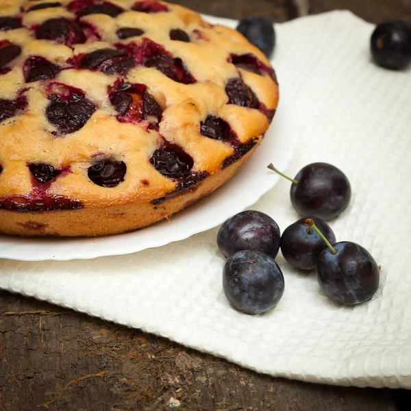 Plum cake on a dark wood background — Stock Photo, Image