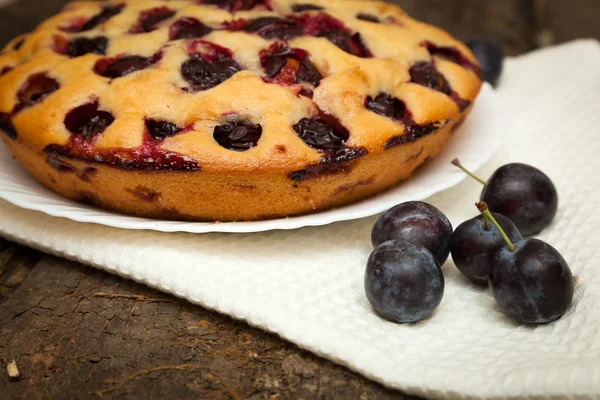 Bolo de ameixa em um fundo de madeira escura — Fotografia de Stock