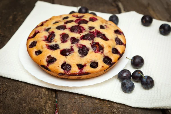 Torta di prugne su uno sfondo di legno scuro — Foto Stock