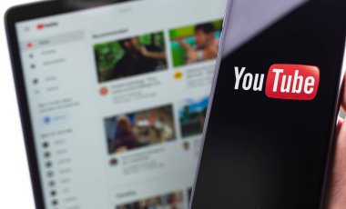 Ekran akıllı telefonunda YouTube logosu ve dizüstü bilgisayarda YouTube ana sayfası. YouTube herkesin izleyebileceği ücretsiz bir video paylaşım uygulamasıdır. Moskova, Rusya - 20 Nisan 2020