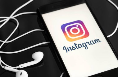 Ekran akıllı telefonunda Instagram ve siyah arka planda Apple Earpods. Instagram akıllı telefonlar için fotoğraf paylaşım uygulamasıdır. Moskova, Rusya - 10 Haziran 2020