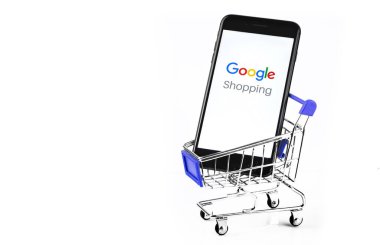 Üzerinde Google Alışveriş logosu olan akıllı telefonlu alışveriş arabası. Google dünyadaki en büyük internet arama motorudur. Moskova, Rusya - 10 Temmuz 2020