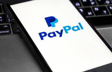 Akıllı telefon ve not defterinde PayPal logosu var. Paypal internet tabanlı dijital para transferi servisidir. Moskova, Rusya - 21 Mayıs 2020