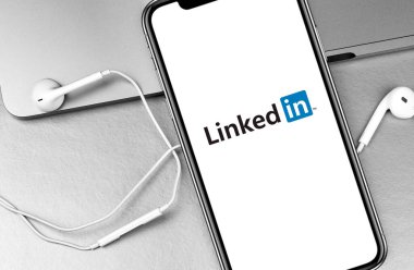 Kulaklıklar ve kulaklıklar ekran iPhone 'una bağlı uygulama logosu. LinkedIn, iş bağlantılarını bulmak ve kurmak için kullanılan bir sosyal ağ. Moskova, Rusya 15 Ağustos 2020
