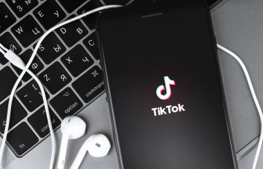 Sceen akıllı telefonundaki TikTok logosu ve defter arkaplanındaki Kulaklıklar. TikTok video yaratmak ve paylaşmak için bir uygulamadır. Moskova, Rusya - 28 Temmuz 2020