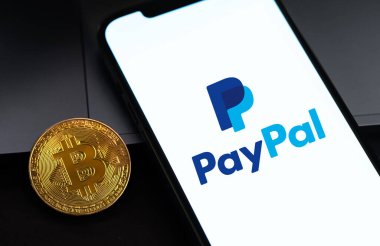 Ekran iPhone 'unda PayPal logosu ve karanlıkta bitcoin kripto para birimi. Paypal internet tabanlı dijital para transferi servisidir. Moskova, Rusya - 3 Aralık 2020