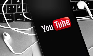 Sceen iPhone ve Apple Earpod 'ların kulaklıklarında YouTube logosu. YouTube herkesin izleyebileceği ücretsiz bir video paylaşım uygulamasıdır. Moskova, Rusya - 28 Kasım 2020