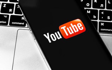 Sceen iPhone ve MacBook 'ta YouTube logosu var. YouTube herkesin izleyebileceği ücretsiz bir video paylaşım uygulamasıdır. Moskova, Rusya - 28 Kasım 2020