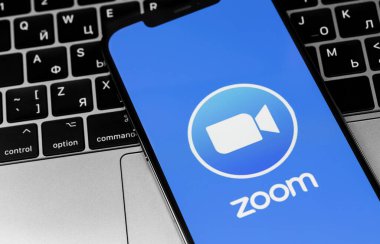 MacBook ile birlikte ekrandaki iPhone uygulamasının logosunu yakınlaştır. Zoom Video Communications, uzaktan konferans hizmeti veren bir şirket. Moskova, Rusya - 3 Aralık 2020