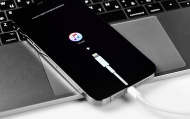 Yıldırım kablolu Apple iPhone, ekranında iTunes logosu. Apple, online hizmetler tasarlayan, geliştiren, çok uluslu bir teknoloji şirketidir. Moskova, Rusya - 14 Ocak 2021