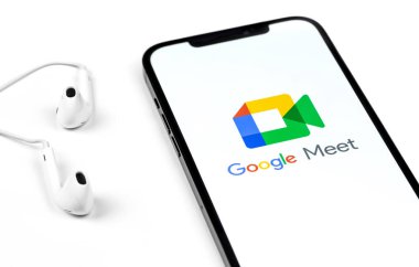 Ekran akıllı telefonunda Google Meet uygulaması, kulaklıklı iPhone. Google Meet, Google tarafından geliştirilen bir video arama servisidir. Moskova, Rusya - 16 Ocak 2021