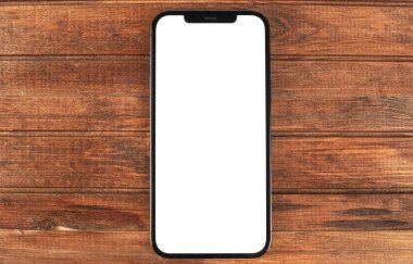 Akıllı telefon maketi iPhone 12 Pro Max ahşap masa üzerinde boş beyaz ekran, üst görünüm. Apple çok uluslu bir teknoloji şirketidir. Moskova, Rusya - 14 Ocak 2021