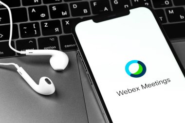 Webex Toplantı simgesi mobil uygulaması akıllı telefon iPhone ve kulaklıklar, not defteri. Webex Toplantılar, bulut toplantısı veya video konferansı sunan popüler uygulamalardan biridir. Moskova, Rusya - 3 Aralık 2020