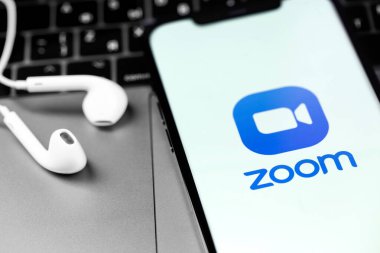 Apple Earpod kulaklıklı akıllı telefon iPhone ekranında zoom uygulaması logosu. Not defterini kapat. Zoom Video Communications, uzaktan konferans hizmeti veren bir şirket. Moskova, Rusya - 3 Aralık 2020