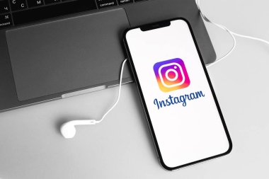Instagram logo mobil uygulaması ekrandaki akıllı telefon iPhone ve kulaklıklar, MacBook not defteri. Instagram akıllı telefonlar için fotoğraf paylaşım uygulamasıdır. Moskova, Rusya - 12 Ocak 2021