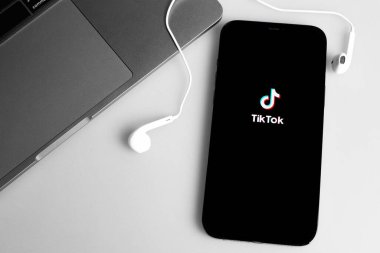 TikTok logo mobil uygulaması ekran iPhone ve Kulaklıklar, Macbook defteri. TikTok video yaratmak ve paylaşmak için bir uygulamadır. Moskova, Rusya - 12 Ocak 2021