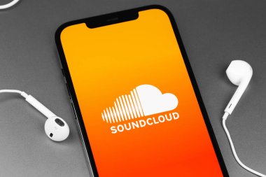 Kulaklıklı akıllı telefon ekranında Soundcloud logo mobil uygulaması. SoundCloud küresel bir çevrimiçi ses dağıtım platformudur. Moskova, Rusya - 11 Mart 2021