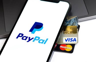 Visa, MasterCard plastik kartlar yakın çekim ve PayPal logosu ekran akıllı telefonunda. Paypal internet tabanlı dijital para transferi servisidir. Moskova, Rusya - 16 Nisan 2021