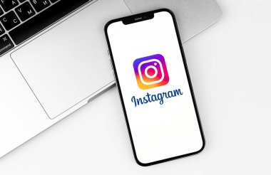 Instagram mobil uygulaması ekrandaki akıllı telefon iPhone, not defteri, iş yeri arka planı. Instagram akıllı telefonlar için fotoğraf paylaşım uygulamasıdır. Moskova, Rusya - 14 Nisan 2021