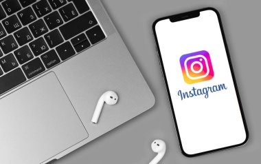 Instagram mobil uygulaması ekranda AirPods 'lu akıllı telefon iPhone, Macbook yakın plan. Instagram akıllı telefonlar için fotoğraf paylaşım uygulamasıdır. Moskova, Rusya - 12 Haziran 2021