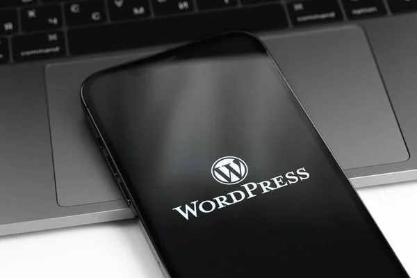 屏幕智能手机上的Wordpress标志 带有笔记本电脑Macbook键盘特写的Iphone Wordpress 开源网站内容管理系统 2021年4月11日 俄罗斯莫斯科 — 图库照片