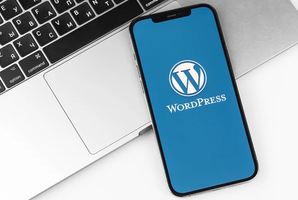 Wordpress在屏幕智能手机上的标识移动应用程序 带有笔记本电脑的Iphone 职场背景 Wordpress 开源网站内容管理系统 2021年4月14日 俄罗斯莫斯科 — 图库照片
