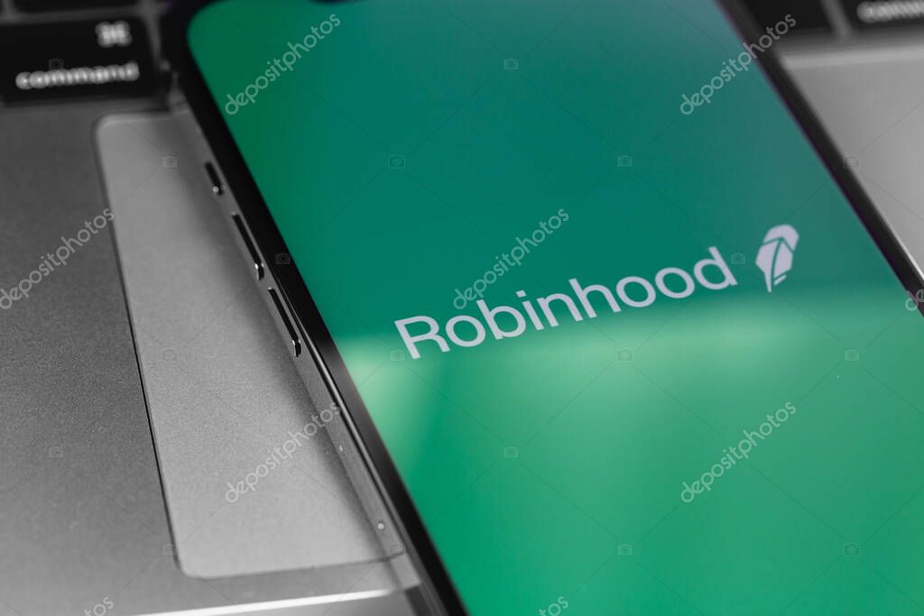 Robinhood mobile app on screen smartphone, iPhone with notebook keyboard. Robinhood Markets, Inc. - American company providing financial services. Moscow, Russia - February 16, 2021
