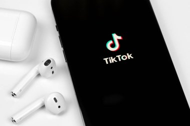 TikTok mobil uygulaması AirPods kulaklıklı akıllı telefon iPhone ekranında. TikTok video yaratmak ve paylaşmak için bir uygulamadır. Moskova, Rusya - 12 Haziran 2021