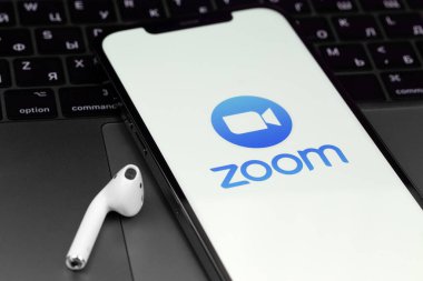 Mobil logo uygulamasını AirPods ve MacBook 'lu akıllı telefon iPhone ekranına yakınlaştır. Zoom Video Communications, uzaktan konferans hizmeti veren bir şirket. Moskova, Rusya - 12 Haziran 2021