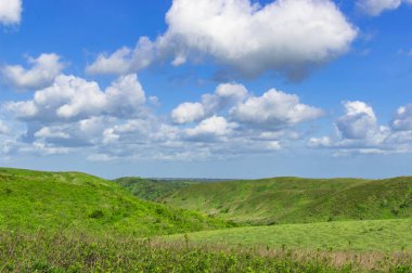 Bulutlu tepelerin ve mavi gökyüzünün fotoğrafı. Tepeler ve mavi gökyüzü.