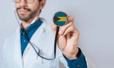 Doctor holding stethoscope with Bahamas flag. Bahamas health and care concept. Bahamas flag on stethoscope