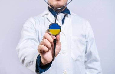Doctor hands holding stethoscope with Ukraine flag. Ukraine health and care concept