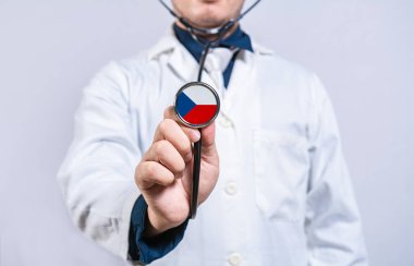 Doktor steteskop tutuyor, elinde czech bayrağı var. Çek sağlık ve bakım kavramı
