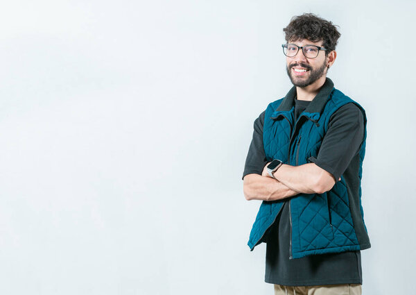 Улыбающийся и красивый парень в очках, держащий руки скрещенными в изоляции. Портрет крутого и красивого случайного мужчины в очках и скрещенных руках