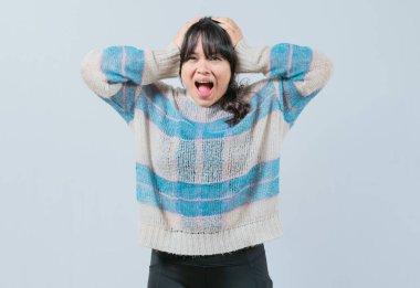 Panikleyen Asyalı kız kafasını izole etmiş. Telaşlı ve endişeli bir kadın başını tutuyor.