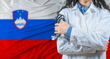Slovenya bayrağı geçmişi olan bir sağlık uzmanı. Slovenya bayrağının arka planında steteskop tutan profesyonel doktor