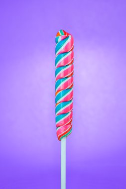 Mor bir arka plan üzerinde çubuklar şeklinde lolipop